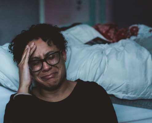 A woman upset by a bed
