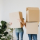 Two people carrying cardboard boxes