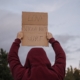 "Love shouldn't hurt" cardboard sign