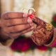 A person holding two wedding rings