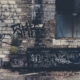 A brick wall with grafiti covered on it